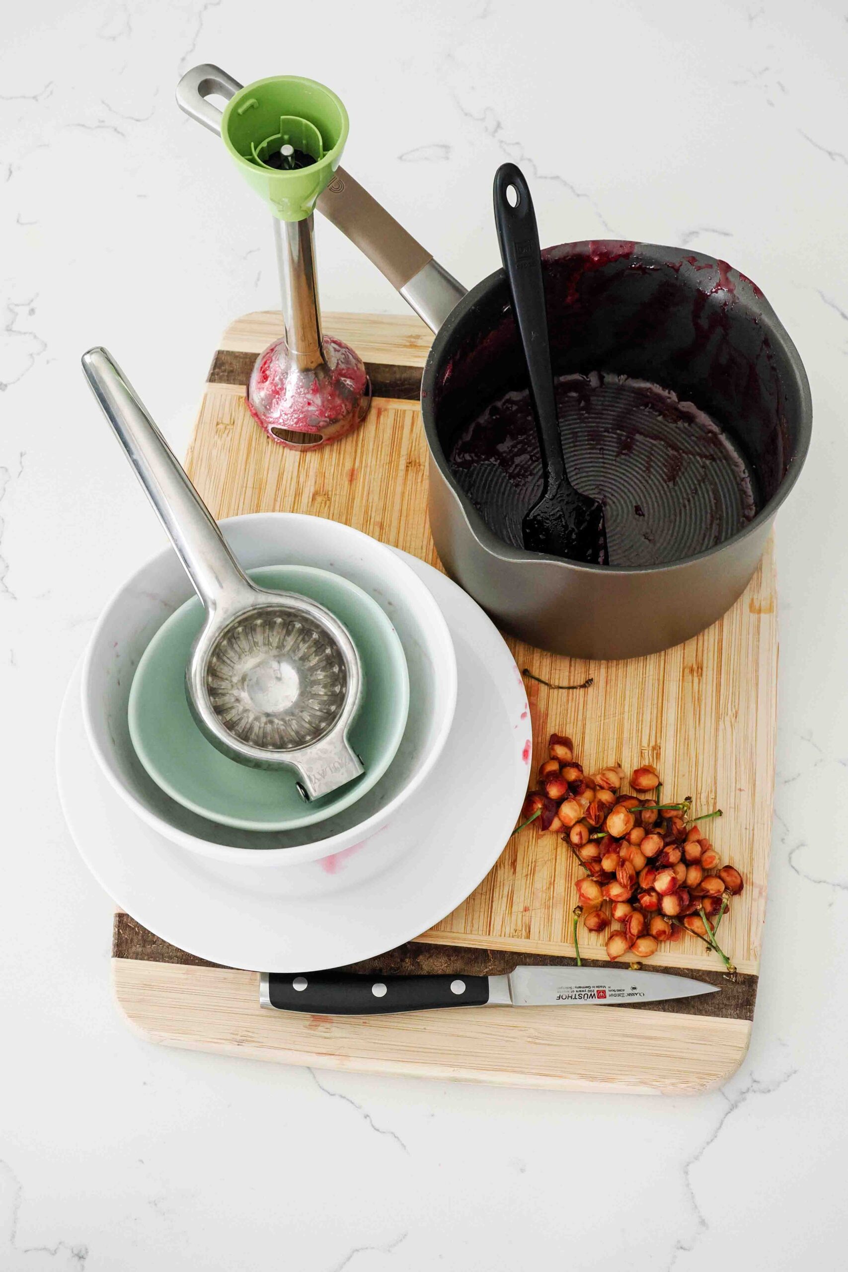 Dishes used to make small batch cherry jam on a kitchen counter.