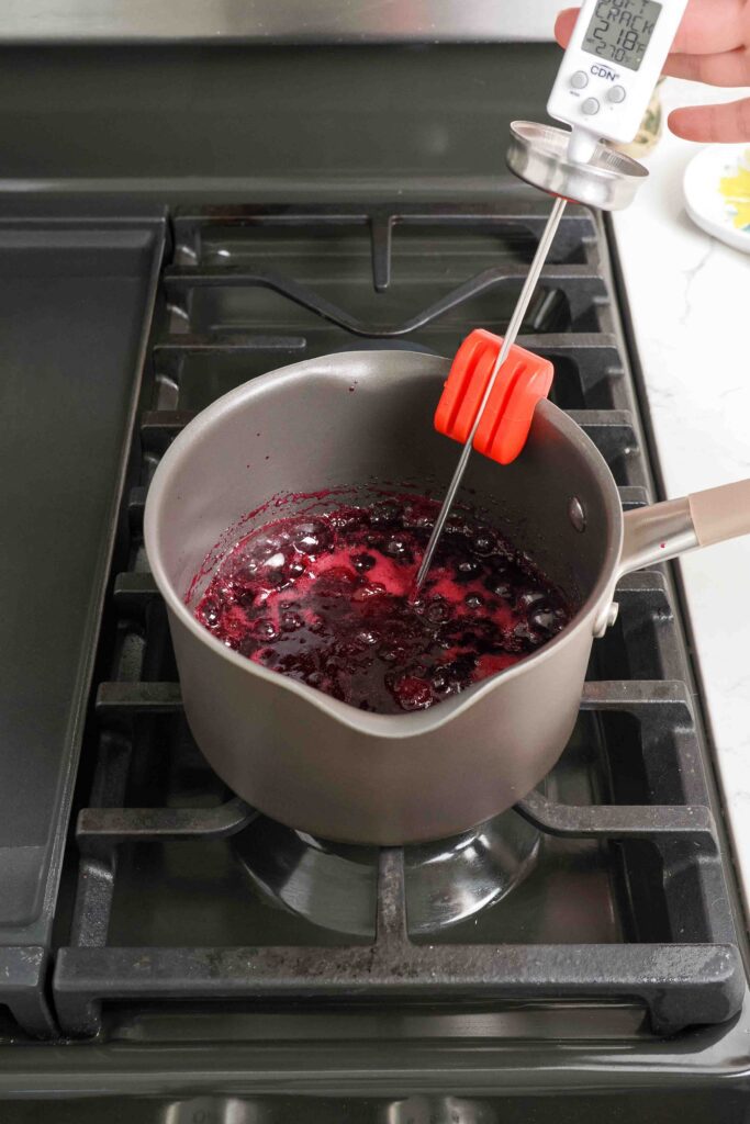 A thermometer in a pot of cherry jam reads 218°F.