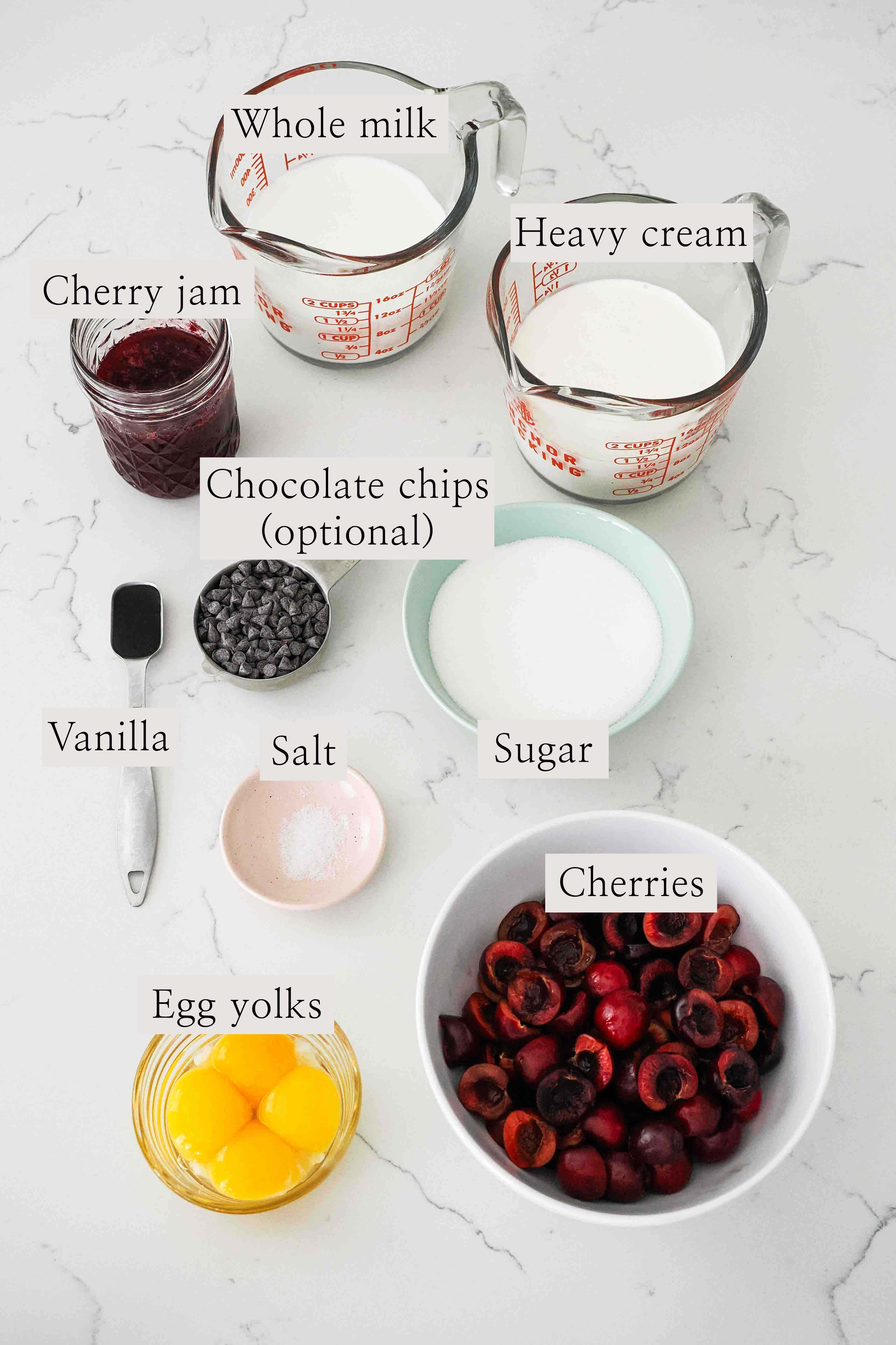 Ingredients to make black cherry ice cream on a quart counter.