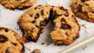 An oatmeal chocolate chip cookie is broken in half.