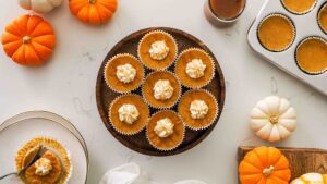 An overhead image of mini pumpkin cheesecakes on a wooden stand.