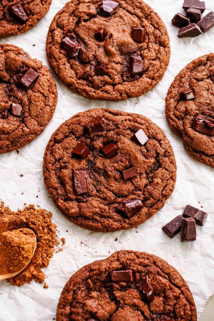 Double chocolate chip cookies on crinkled parchment paper.