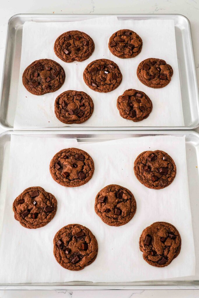 Baked double chocolate chip cookies on a baking sheet.