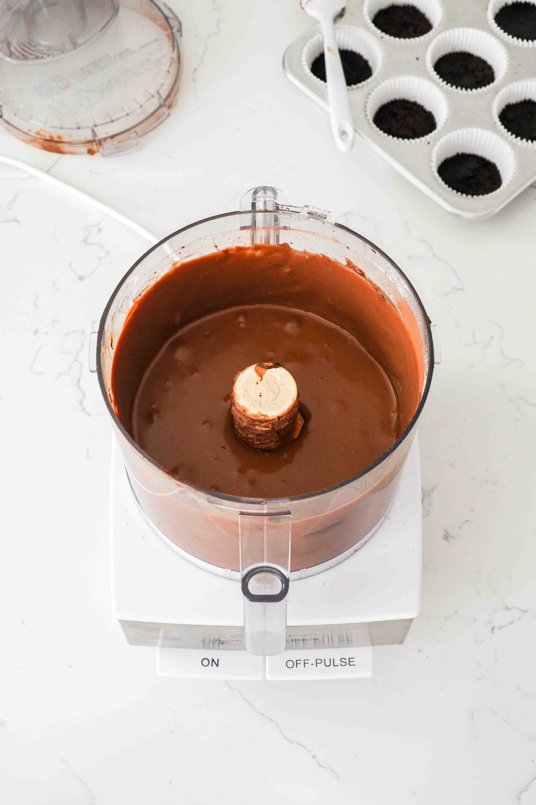 Smooth and creamy chocolate cheesecake filling in a food processor bowl.