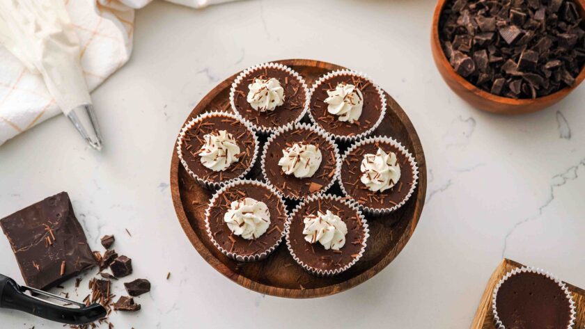 An overhead view of mini chocolate cheesecakes on a cake stand.