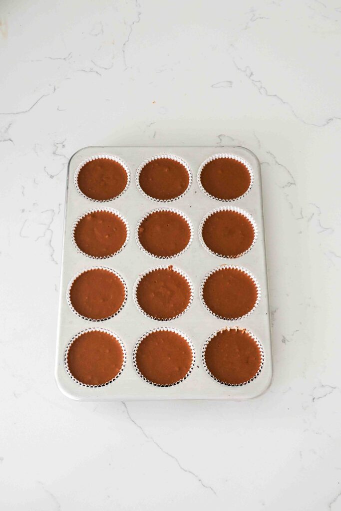 Unbaked mini chocolate cheesecakes in a muffin pan.