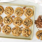 Overhead image of caramel chocolate chip cookies on a baking sheet.