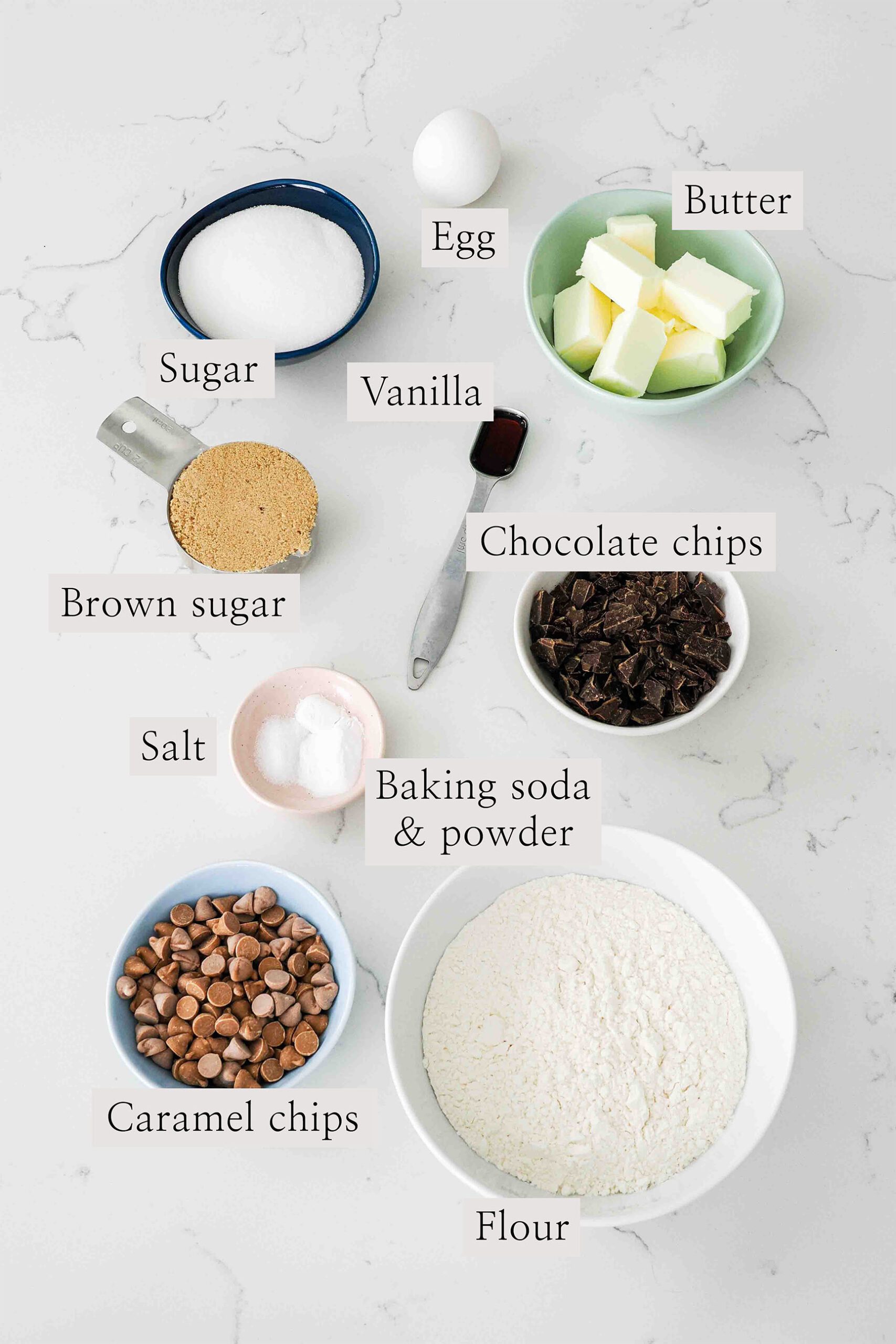 Ingredients needed to make caramel chocolate chip cookies on a quartz counter.