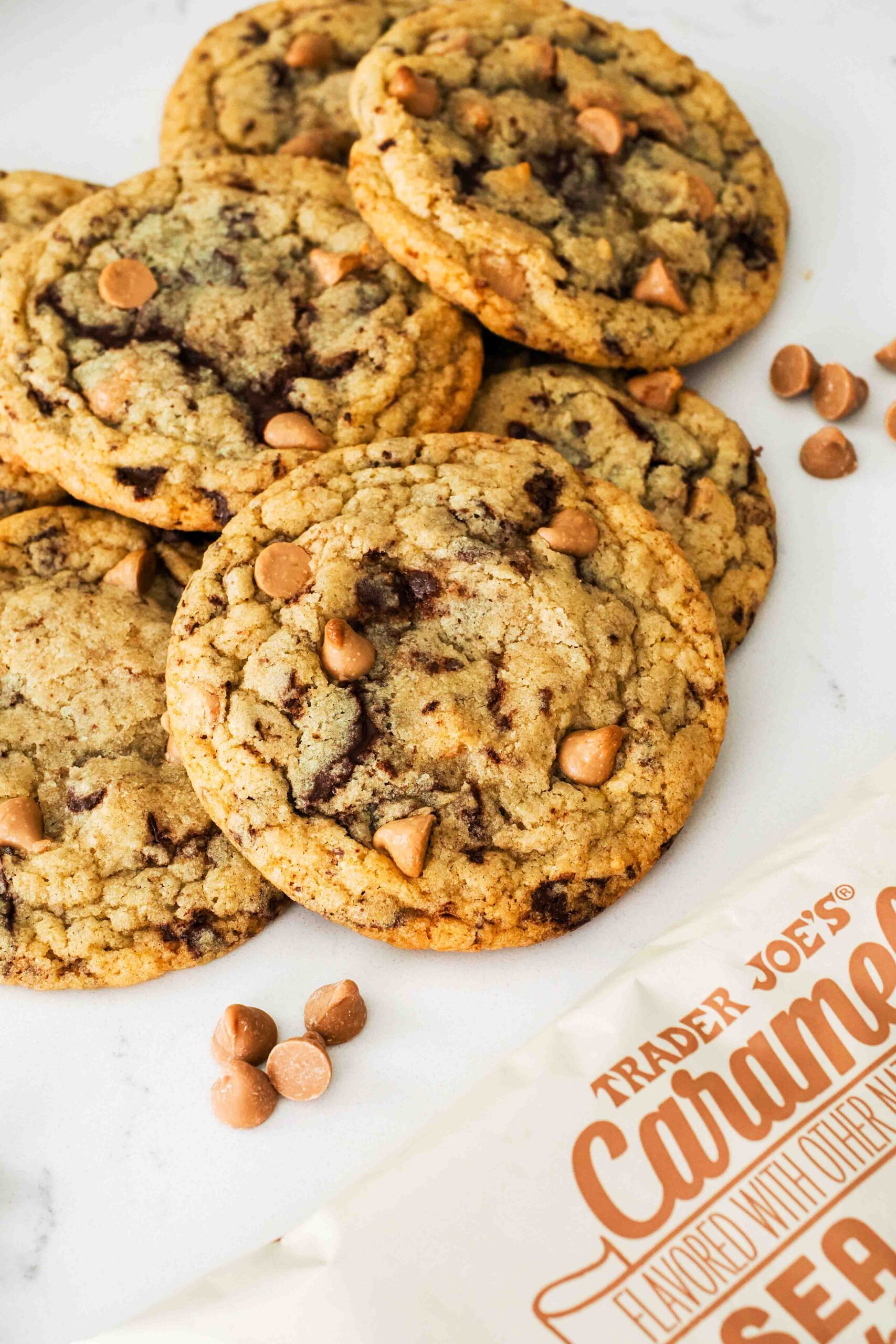 A caramel chocolate chip cookie with a bag of caramel chips in the corner.