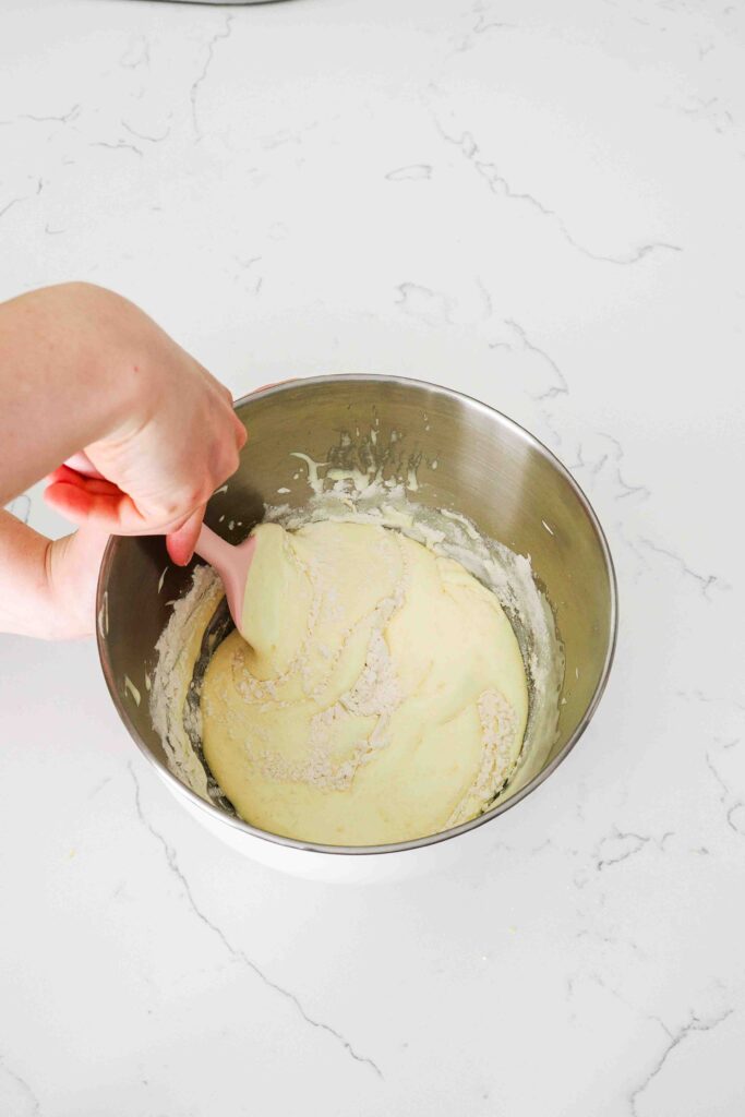 Flour is folded into ribboned eggs.