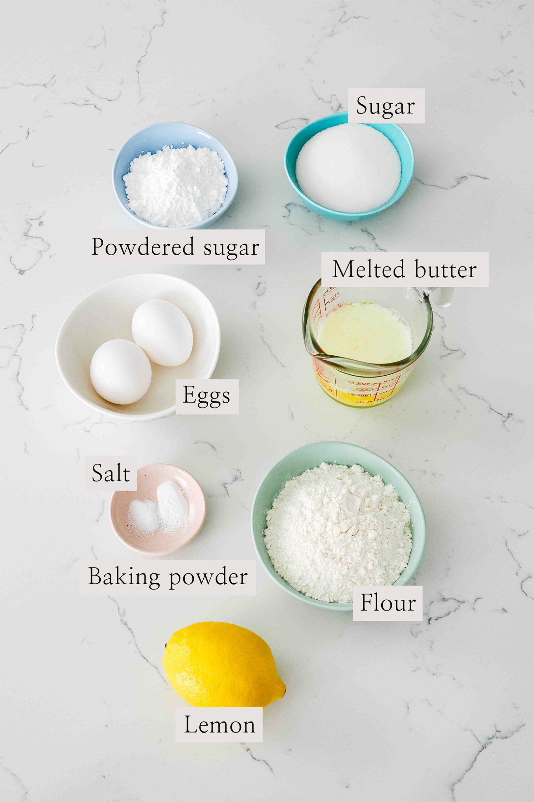 Ingredients for lemon madeleines on a quartz counter.