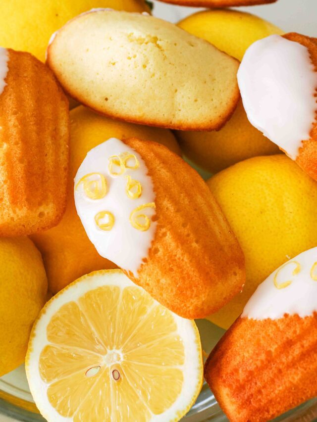 Lemon madeleines in a bowl of lemons.
