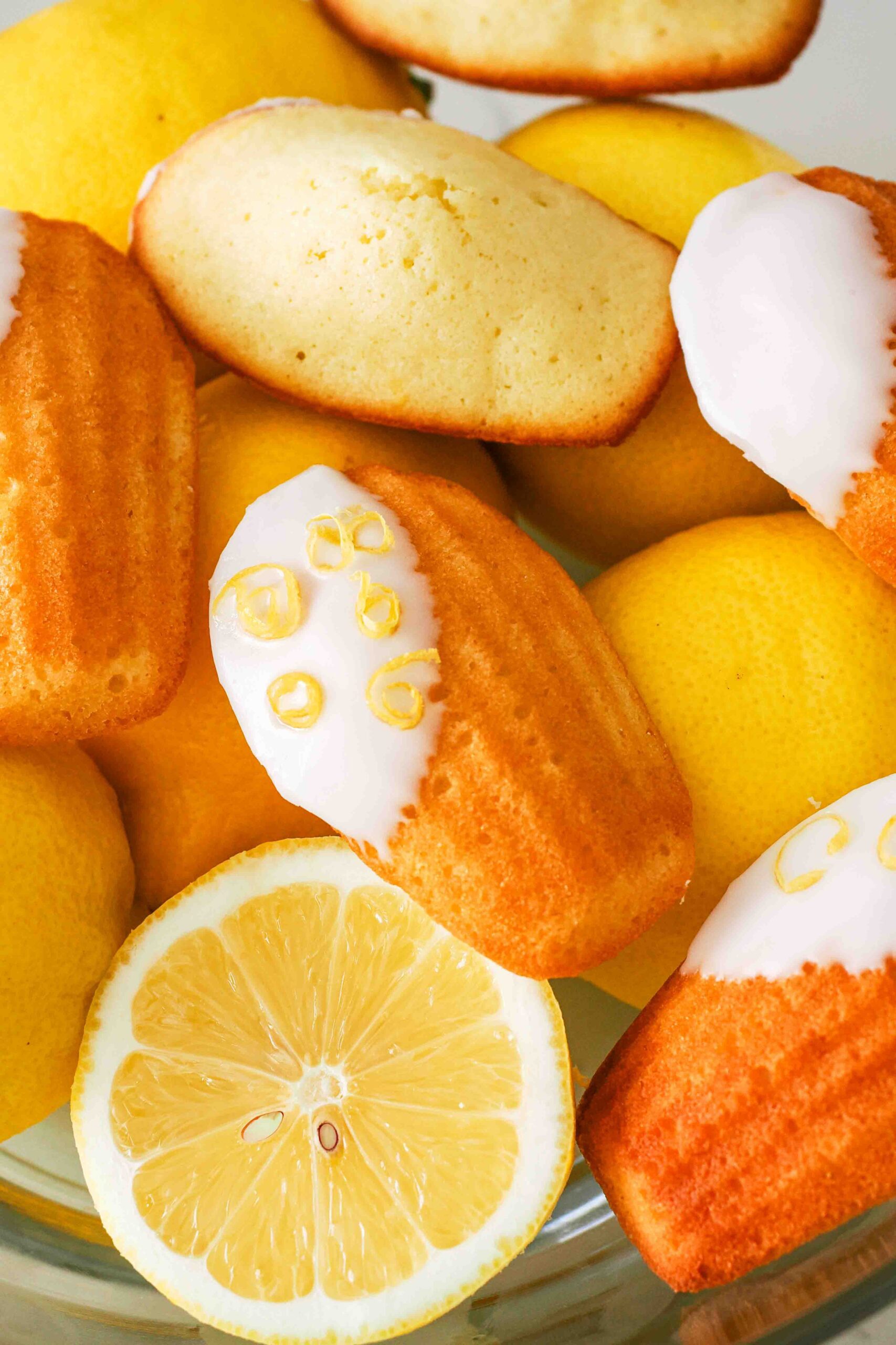 Lemon madeleines in a bowl of lemons.