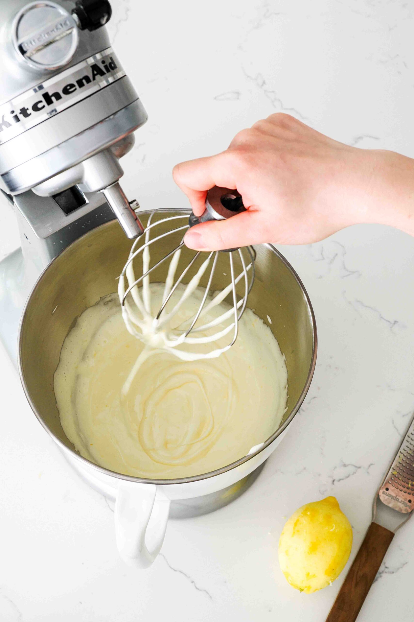 Thick batter drips off a whisk and leaves a trail in the batter before disappearing.