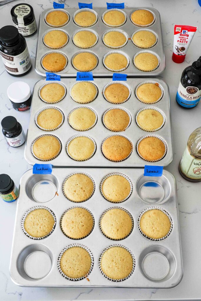 Baked vanilla bean cupcakes in three cupcake pans.