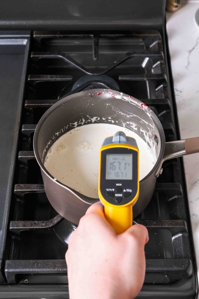 A thermometer reads 167°F over a pot of cooked custard.