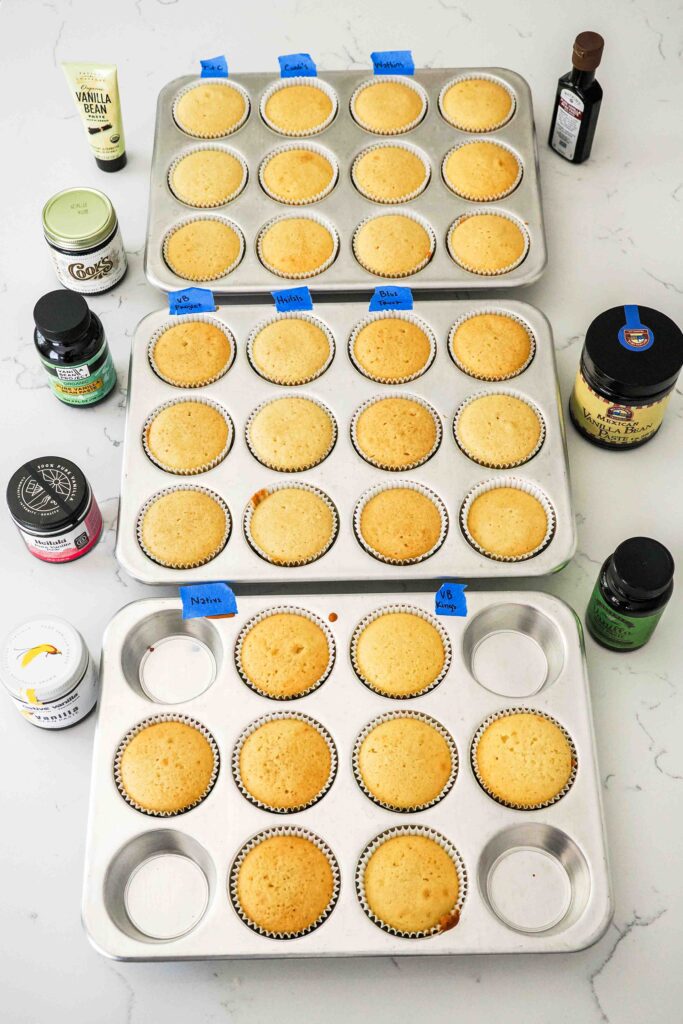 Baked vanilla bean cupcakes in three cupcake pans.
