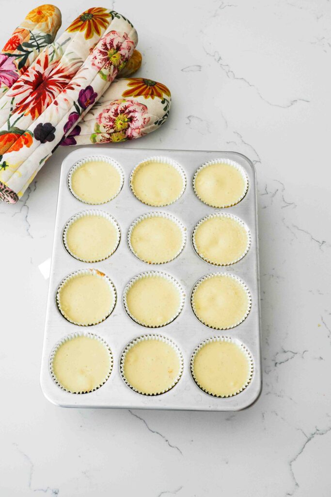 Baked mini vanilla cheesecakes in a muffin pan.
