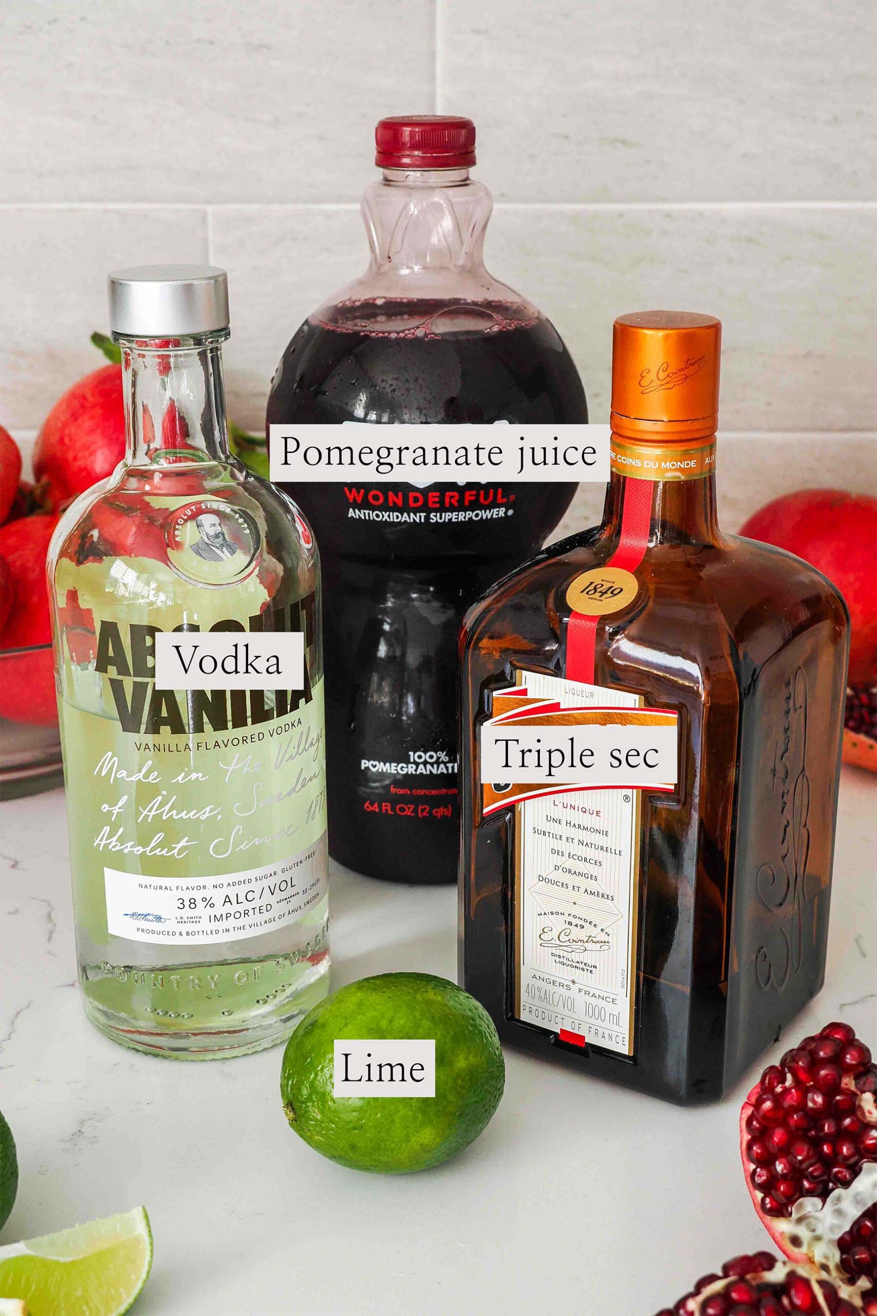 Ingredients needed to make a pomegranate cosmopolitan on a counter.