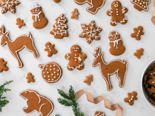 An array of iced gingerbread cookies on a counter.