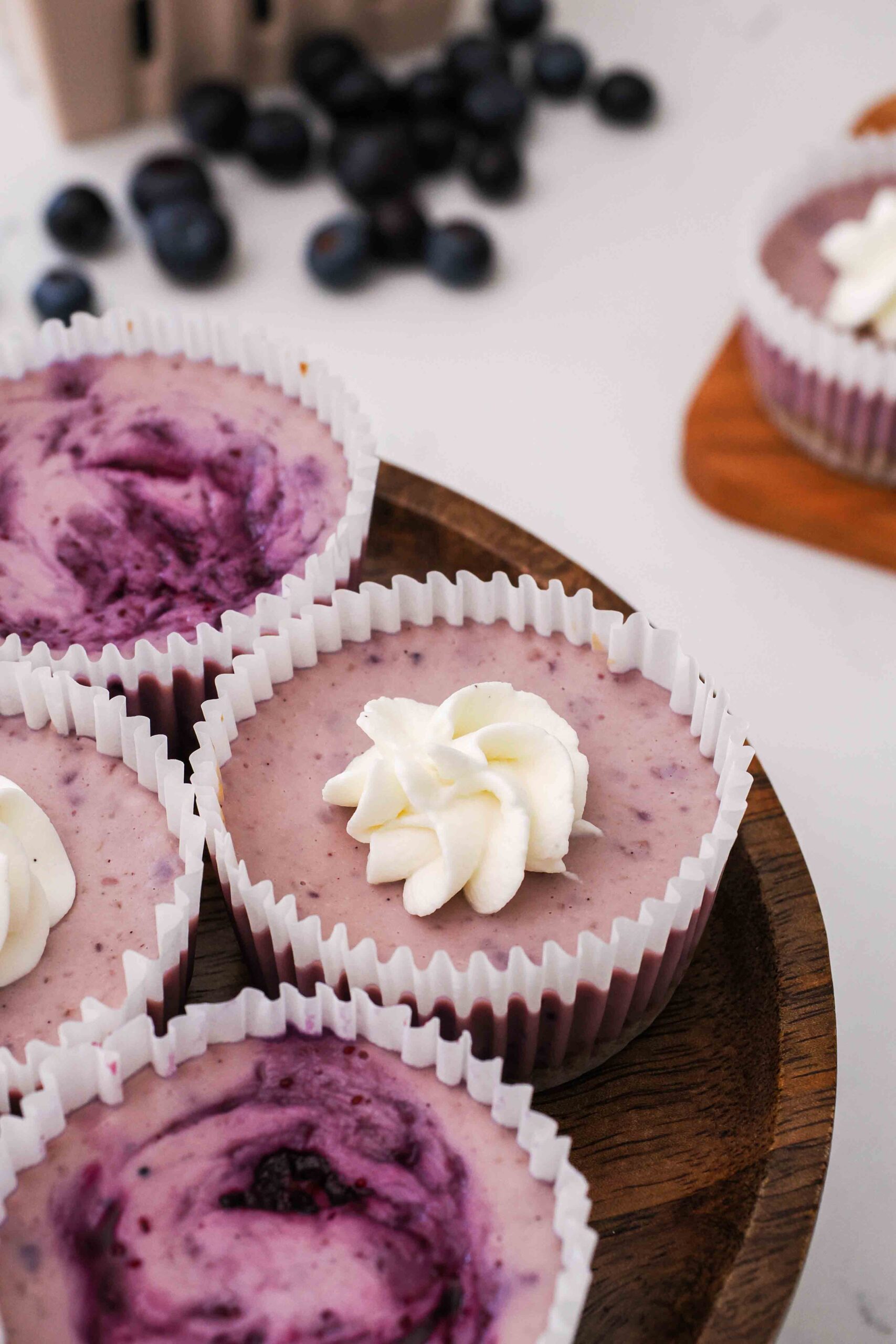 A closeup of a mini blueberry cheesecake on a cake stand.
